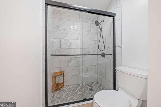 bathroom with an enclosed shower and toilet