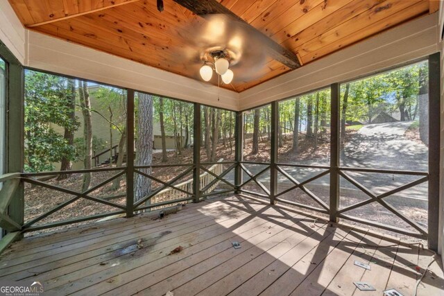 unfurnished sunroom featuring ceiling fan and wood ceiling