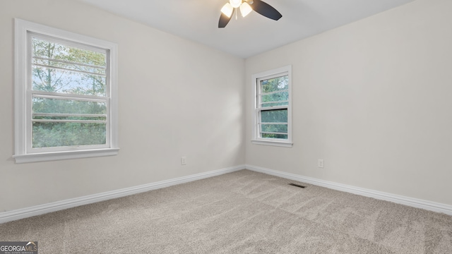 spare room featuring light colored carpet and ceiling fan