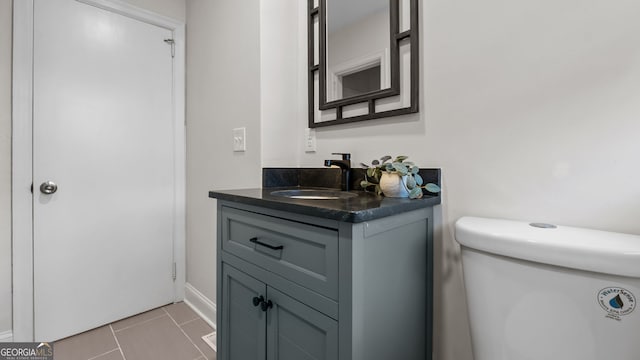 bathroom with tile patterned flooring, vanity, and toilet