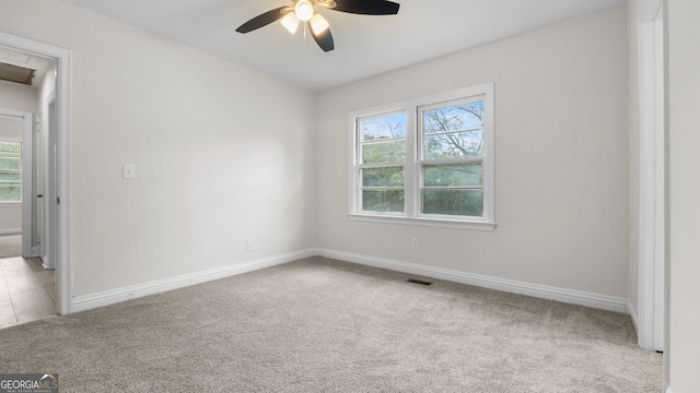 empty room with ceiling fan and light carpet