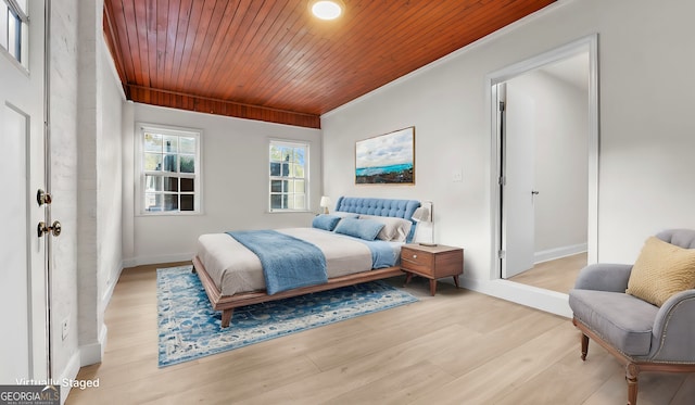 bedroom with wood ceiling, ornamental molding, and light hardwood / wood-style flooring