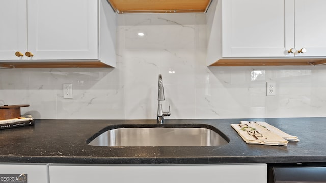 kitchen featuring decorative backsplash, white cabinetry, stainless steel dishwasher, and sink