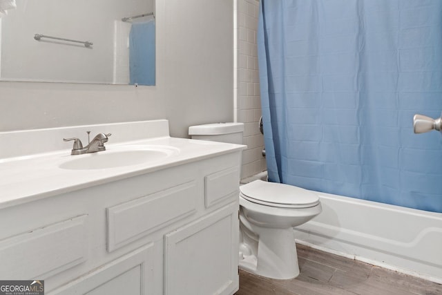 full bathroom with wood-type flooring, vanity, shower / tub combo, and toilet