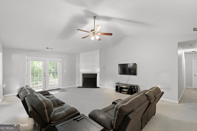 living room featuring ceiling fan, a large fireplace, light carpet, and vaulted ceiling