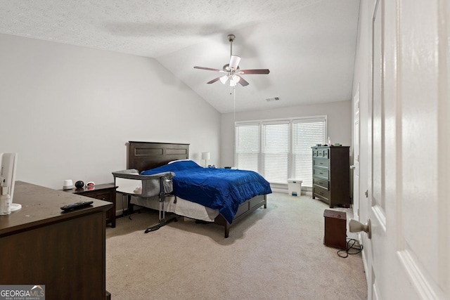 carpeted bedroom with a textured ceiling, ceiling fan, and vaulted ceiling