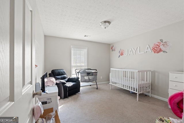 carpeted bedroom with a textured ceiling and a nursery area