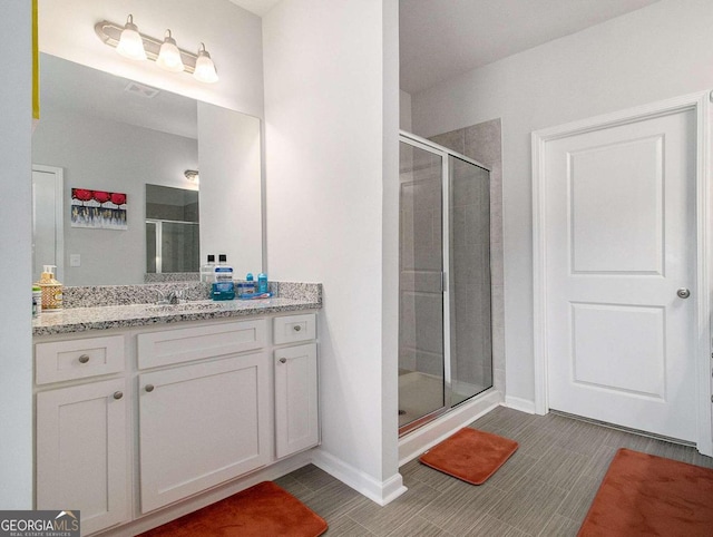 bathroom with vanity and a shower with door