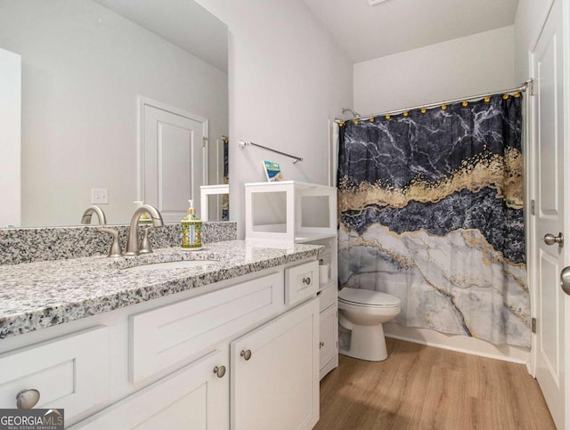 full bathroom featuring hardwood / wood-style flooring, vanity, shower / bath combination with curtain, and toilet