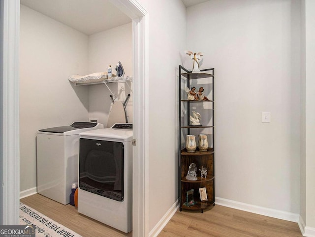 laundry area with washing machine and dryer and light wood-type flooring