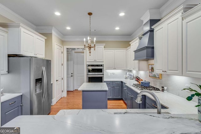 kitchen with tasteful backsplash, a kitchen island, appliances with stainless steel finishes, premium range hood, and decorative light fixtures