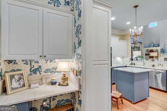 kitchen with hanging light fixtures, light hardwood / wood-style floors, stainless steel dishwasher, white cabinets, and a notable chandelier