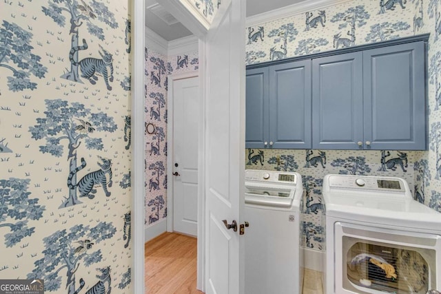 laundry area featuring ornamental molding, hardwood / wood-style floors, separate washer and dryer, and cabinets