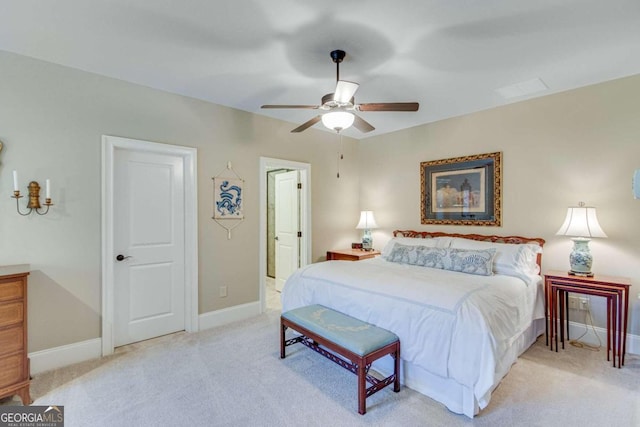 bedroom with light carpet, ensuite bath, and ceiling fan