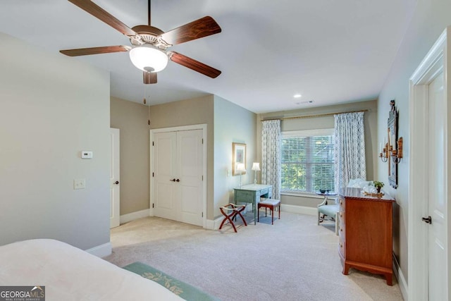 bedroom featuring light colored carpet, a closet, and ceiling fan