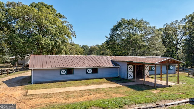 ranch-style home with a front yard and an outbuilding