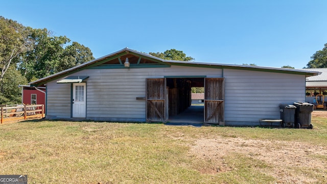 rear view of house featuring a yard and an outbuilding