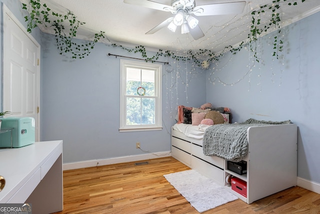 bedroom with light hardwood / wood-style floors and ceiling fan