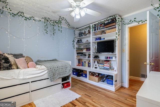 bedroom featuring light hardwood / wood-style floors, crown molding, a textured ceiling, and ceiling fan