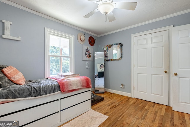 bedroom featuring ceiling fan, crown molding, a textured ceiling, and light wood-type flooring