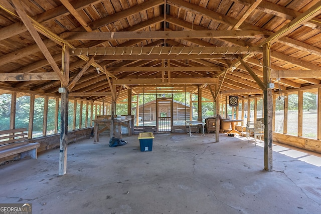 misc room featuring wood ceiling, a healthy amount of sunlight, lofted ceiling with beams, and concrete floors