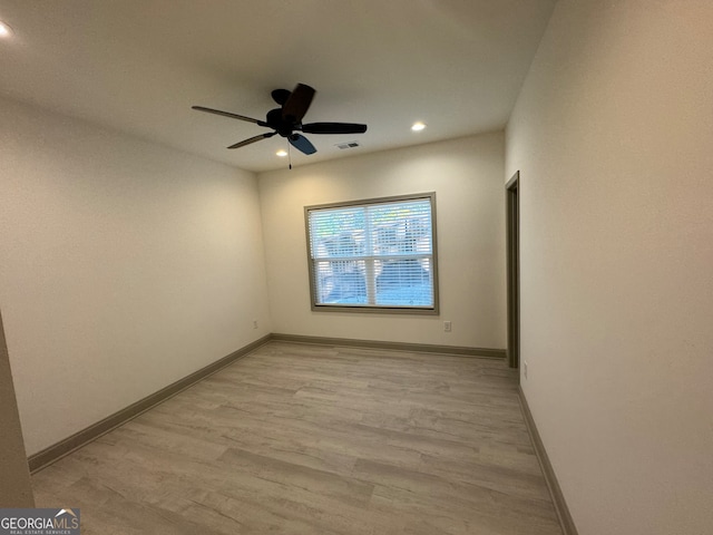 spare room with light wood-type flooring and ceiling fan