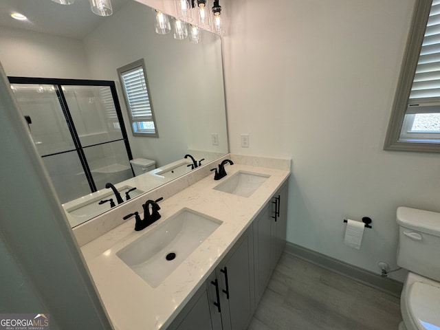 bathroom featuring vanity, hardwood / wood-style flooring, toilet, and an enclosed shower