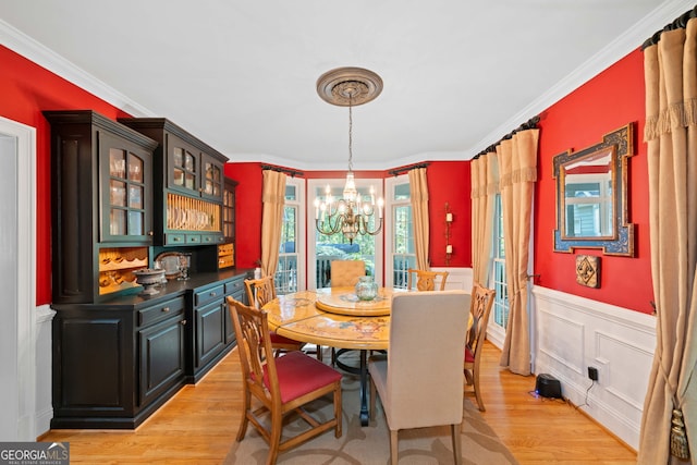 dining room featuring ornamental molding, plenty of natural light, and light wood-type flooring