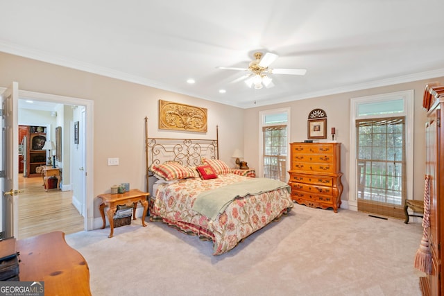 carpeted bedroom featuring ornamental molding, multiple windows, and ceiling fan