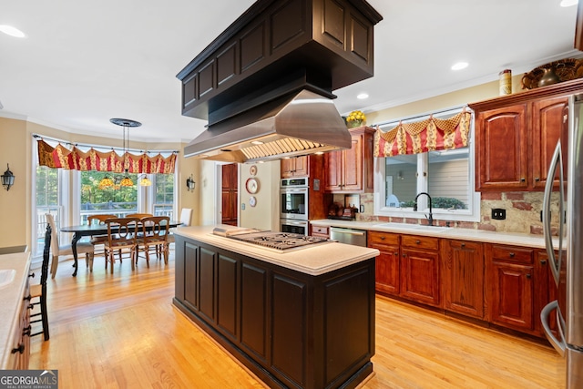 kitchen with backsplash, ornamental molding, sink, light wood-type flooring, and appliances with stainless steel finishes