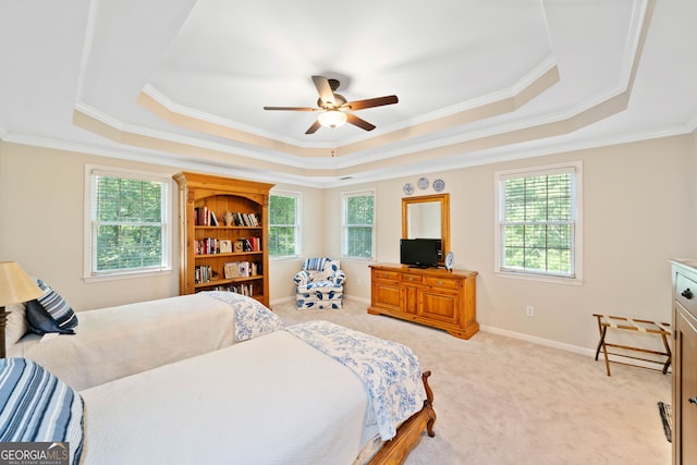 carpeted bedroom with ornamental molding, a raised ceiling, and ceiling fan