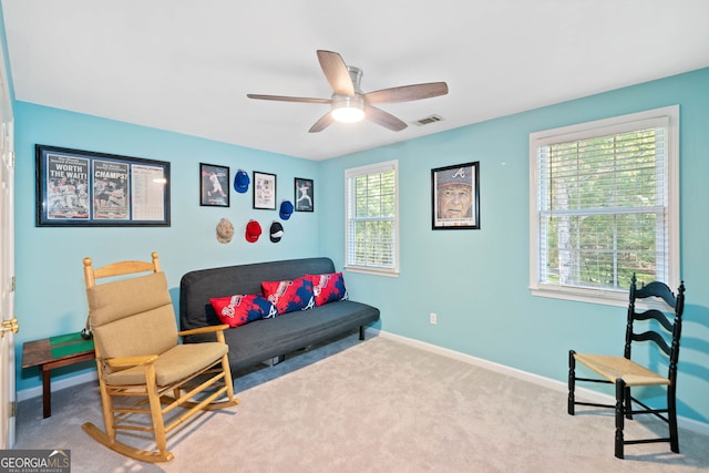 living area with light colored carpet and ceiling fan