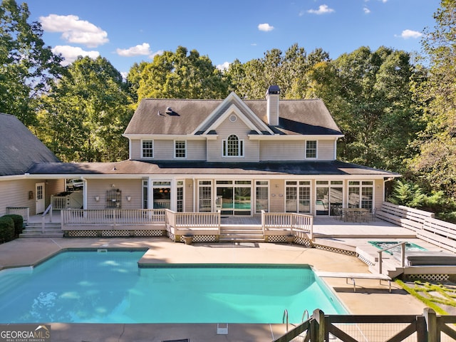 rear view of property featuring a patio area and a swimming pool side deck