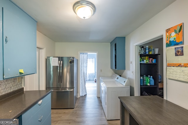 washroom with light hardwood / wood-style floors and washing machine and dryer