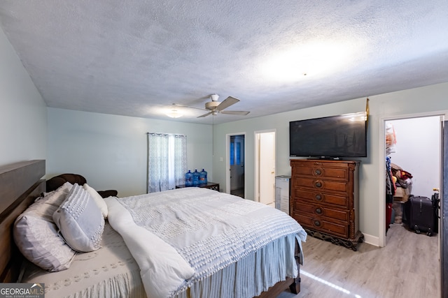 bedroom featuring a closet, ceiling fan, a textured ceiling, and light hardwood / wood-style flooring