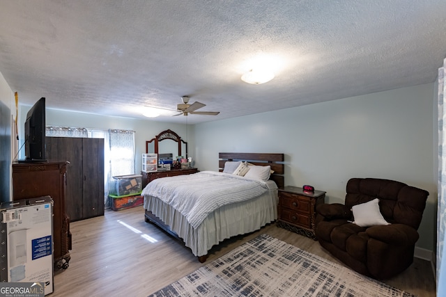 bedroom featuring hardwood / wood-style floors, a textured ceiling, and ceiling fan