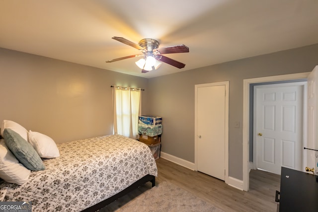 bedroom with dark hardwood / wood-style floors and ceiling fan