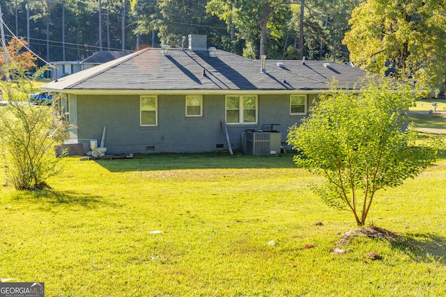 rear view of house with a yard and central AC