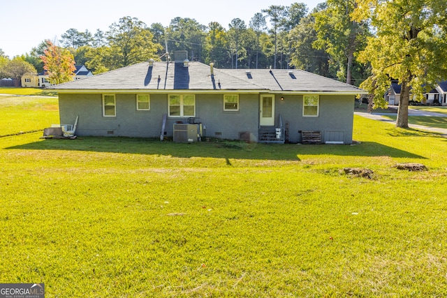 back of house featuring central AC and a yard