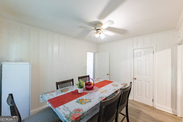 dining room featuring ceiling fan, crown molding, and light wood-type flooring