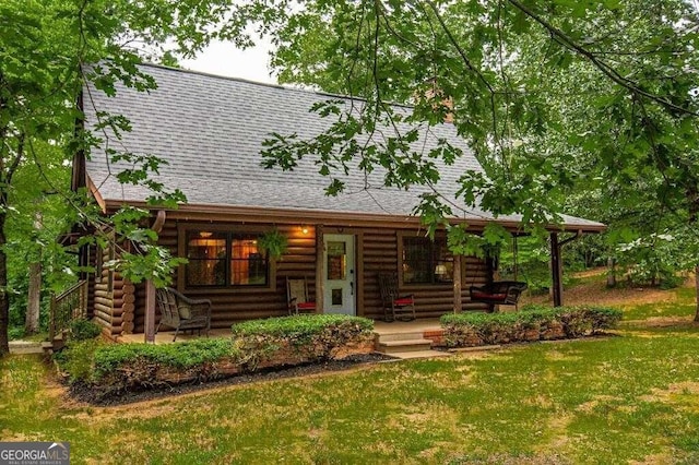 log cabin featuring a front yard and a porch