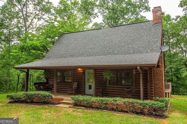 log cabin with a front yard and a porch