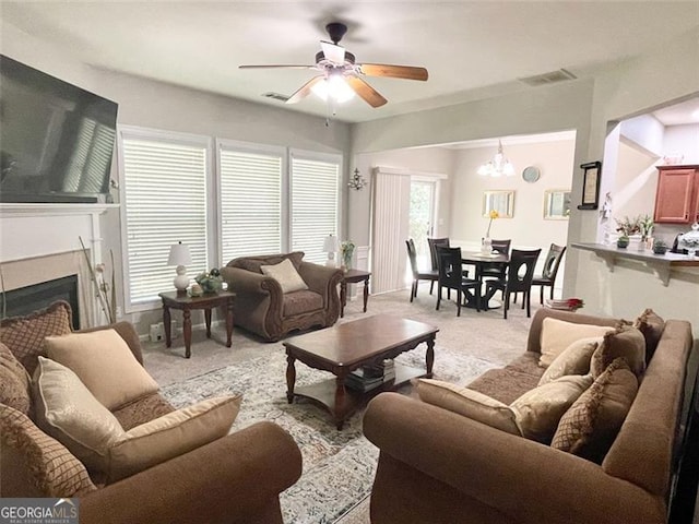 living room with light colored carpet and ceiling fan with notable chandelier