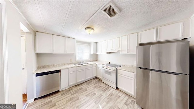 kitchen featuring white cabinetry, a textured ceiling, appliances with stainless steel finishes, and light hardwood / wood-style flooring