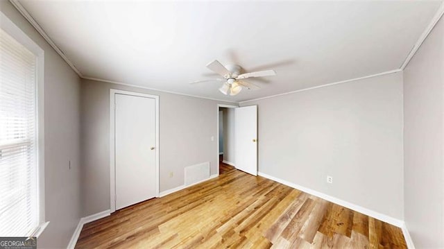 spare room with light hardwood / wood-style floors, crown molding, and ceiling fan