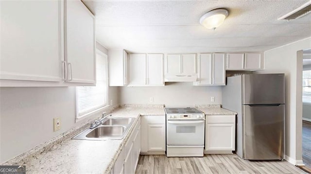 kitchen with sink, stainless steel fridge, white electric range, and white cabinets