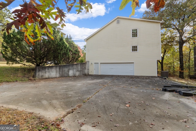 view of side of home featuring cooling unit and a garage