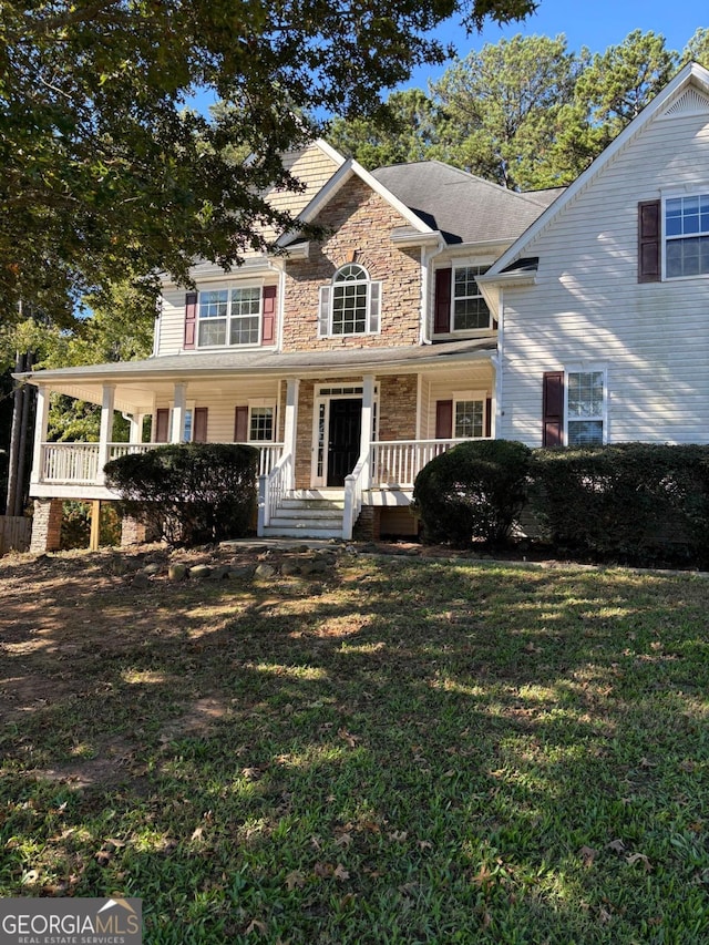 view of front of house with covered porch and a front lawn