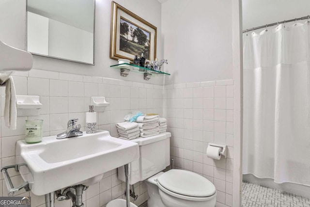 bathroom featuring tile walls, sink, toilet, and walk in shower