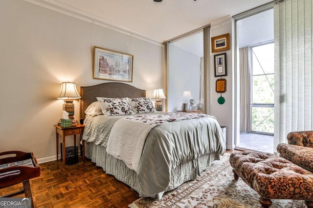 bedroom featuring multiple windows, dark parquet floors, access to exterior, and crown molding